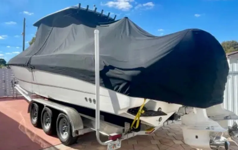 Slide: The Image of 2006 Wellcraft 32 CCF boat covered on a trailer under a clear blue sky. - 4