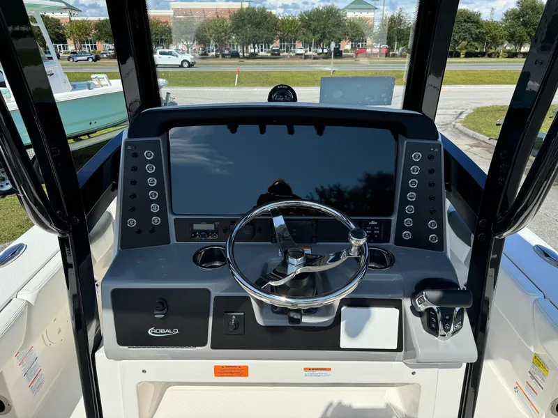 Slide: The Image of 2025 Robalo R246 CAYMAN boat dashboard with steering wheel and control panel. - 11