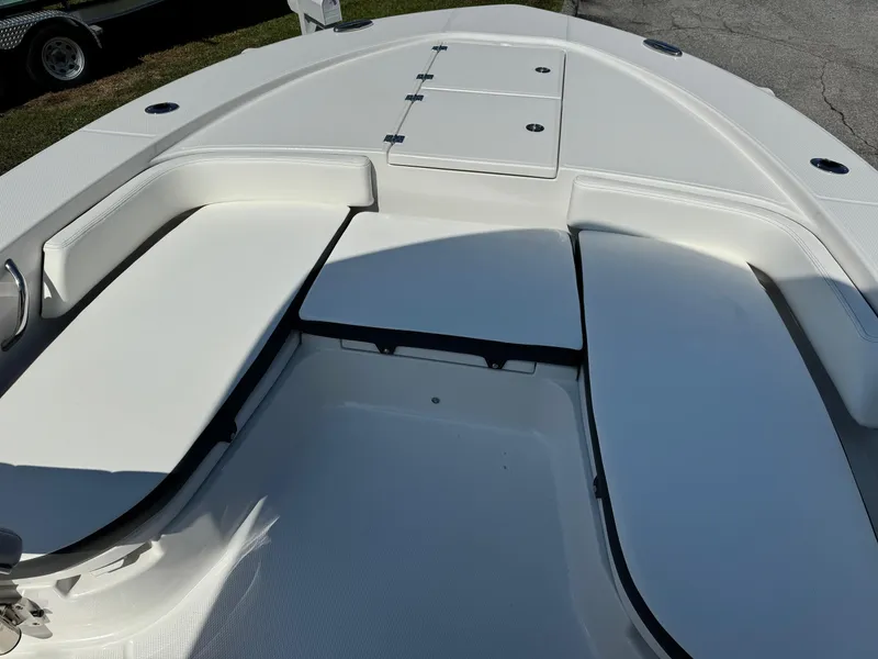 Slide: The Image of 2025 Robalo R246 CAYMAN boat interior with white cushioned seating and storage compartments. - 4