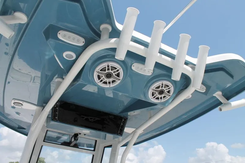Slide: The Image of 2025 Tidewater 2500 CB boat roof with rod holders and speakers against blue sky. - 13
