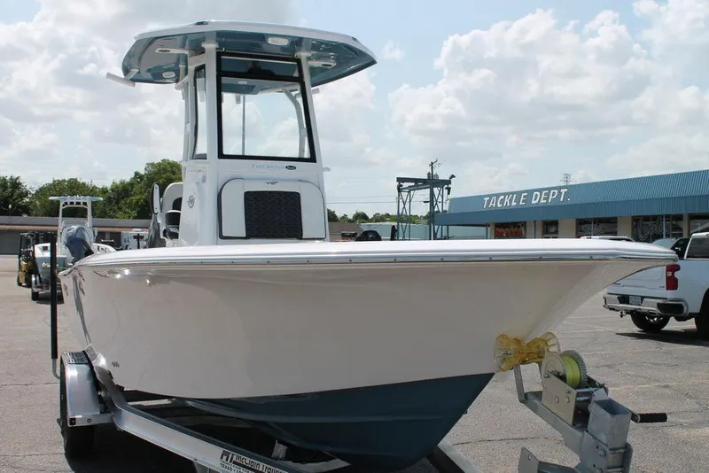 Slide: The Image of 2025 Tidewater 2500 CB boat on trailer in parking lot, tackle shop in background. - 2