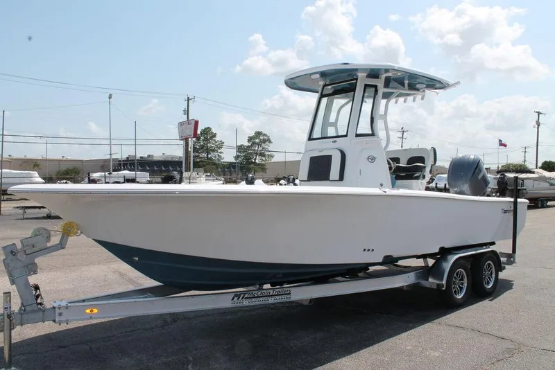 Slide: The Image of 2025 Tidewater 2500 CB boat on trailer, parked outdoors under a cloudy sky. - 3