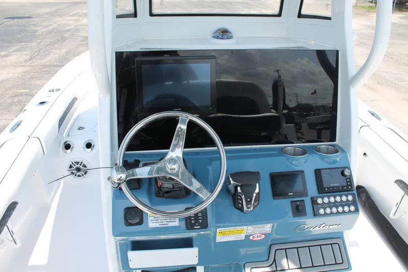 Slide: The Image of 2025 Tidewater 2500 CB boat dashboard with steering wheel and electronic controls. - 5