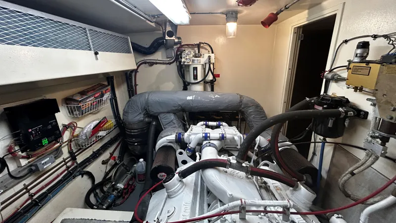 Slide: The Image of Engine room of a 1987 Hatteras 58 Motor Yacht, showcasing mechanical components and wiring. - 13