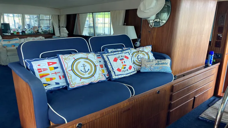 Slide: The Image of Interior of 1987 Hatteras 58 Motor Yacht with nautical-themed cushions and wooden cabinetry. - 4