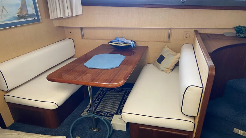 Slide: The Image of Interior of 1987 Hatteras 58 Motor Yacht with cozy dining area and wooden table. - 7