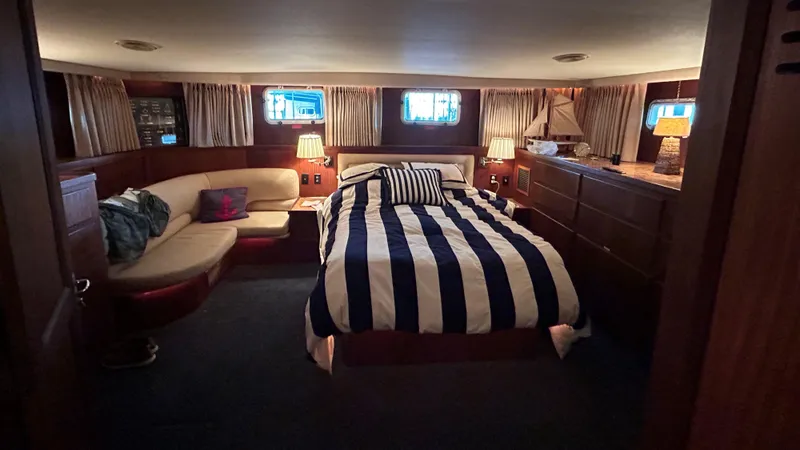 Slide: The Image of Luxurious cabin interior of 1987 Hatteras 58 Motor Yacht with striped bedding and cozy seating. - 8