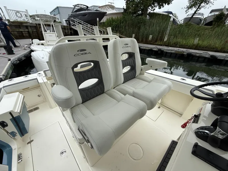 Slide: The Image of 2025 Cobia 265 Open Center Console boat with dual cushioned seats at the helm. - 10