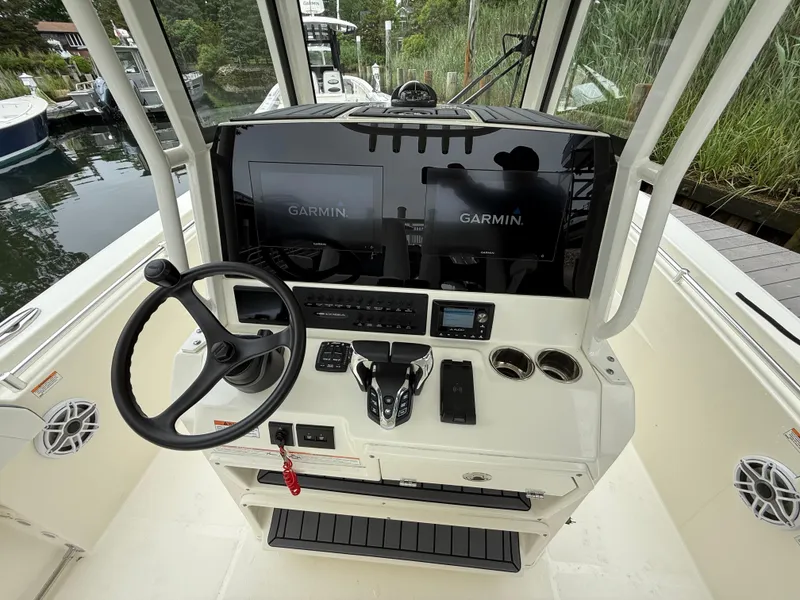Slide: The Image of 2025 Cobia 265 Open Center Console helm with Garmin displays and steering wheel. - 11