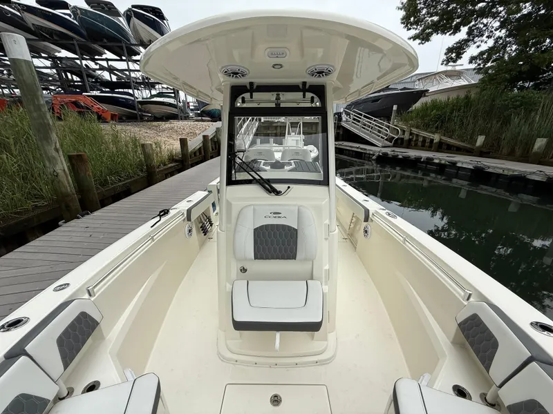 Slide: The Image of 2025 Cobia 265 Open Center Console boat docked near a marina. - 14