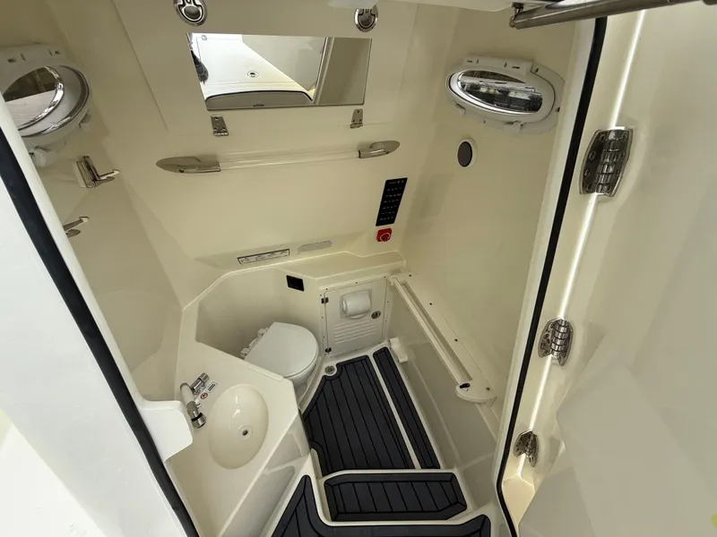 Slide: The Image of 2025 Cobia 265 Open Center Console interior with toilet and sink. - 15