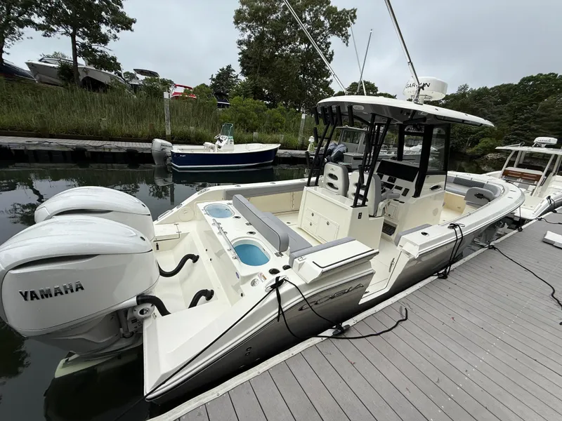 Slide: The Image of 2025 Cobia 265 Open Center Console boat docked with twin Yamaha engines. - 4