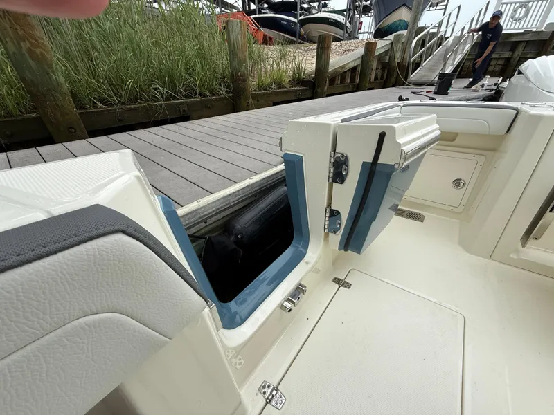 Slide: The Image of 2025 Cobia 265 Open Center Console boat with open side door at dock. - 6