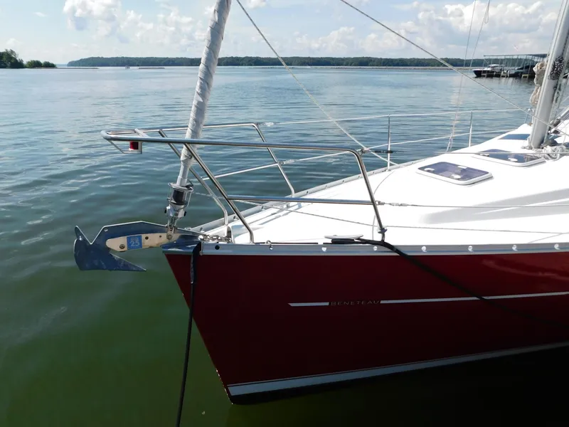Slide: The Image of 2005 Beneteau Oceanis Clipper 323 sailboat with red hull docked on calm water. - 18