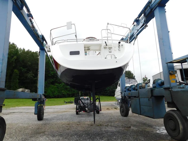 Slide: The Image of 2005 Beneteau Oceanis Clipper 323 sailboat in dry dock, supported by a boat lift. - 2
