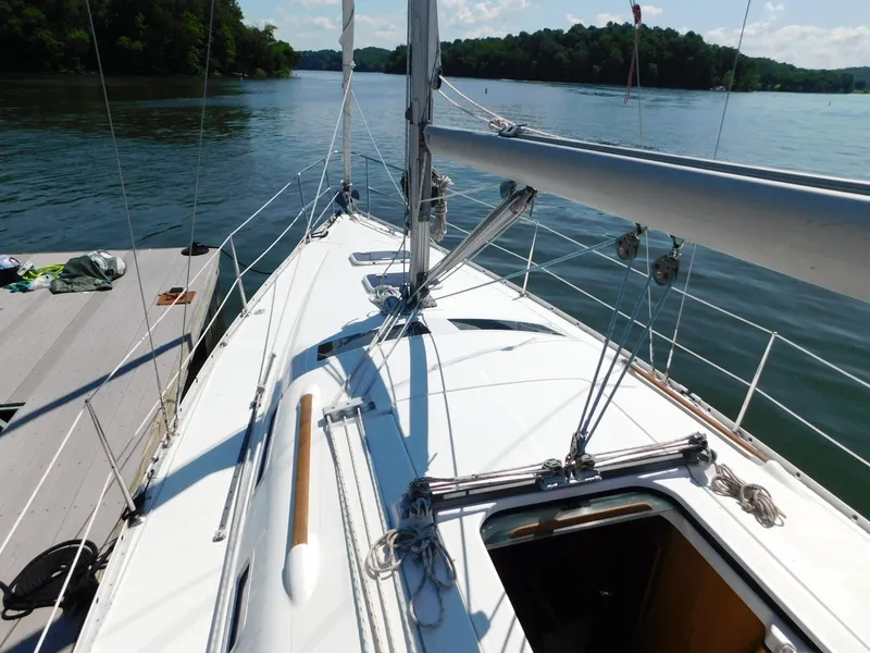 Slide: The Image of 2005 Beneteau Oceanis Clipper 323 sailboat docked on a serene lake. - 27