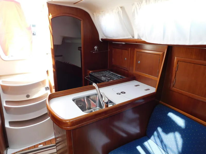 Slide: The Image of Interior of 2005 Beneteau Oceanis Clipper 323 yacht with kitchen and seating area. - 34