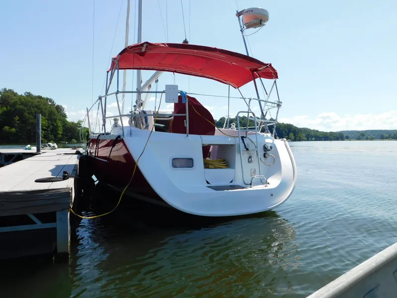 Slide: The Image of 2005 Beneteau Oceanis Clipper 323 sailboat docked with red canopy, calm waters. - 4