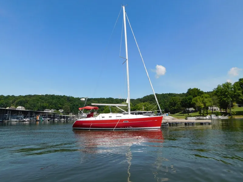 Slide: The Image of Red 2005 Beneteau Oceanis Clipper 323 sailboat on a calm lake with clear blue sky. - 7