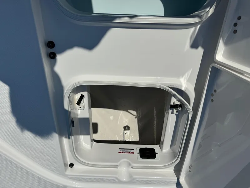 Slide: The Image of 2025 Robalo R246 CAYMAN storage compartment with open hatch, showcasing interior space. - 7