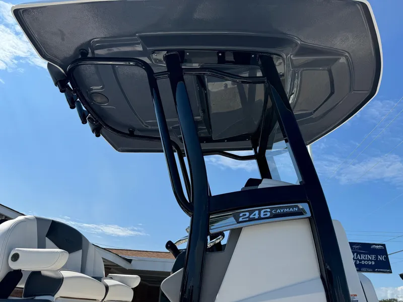 Slide: The Image of 2025 Robalo R246 CAYMAN boat with T-top and seating, viewed from below against blue sky. - 17