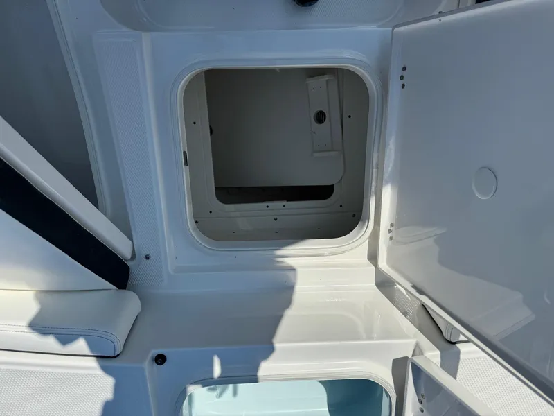 Slide: The Image of 2025 Robalo R246 CAYMAN boat storage compartment with open hatch, showcasing interior space. - 5