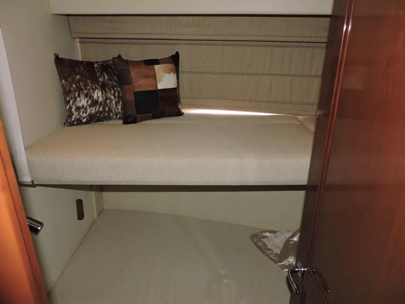 Slide: The Image of 2010 Carver 56 Voyager SE cabin with bunk beds and decorative pillows. - 48