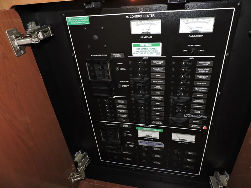 Slide: The Image of AC control panel of 2010 Carver 56 Voyager SE yacht, showing circuit breakers and switches. - 20