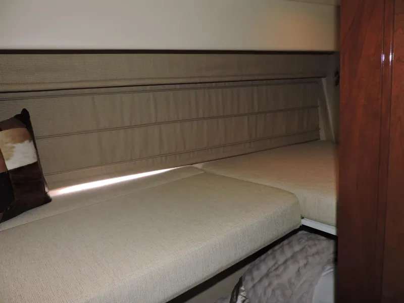 Slide: The Image of 2010 Carver 56 Voyager SE interior cabin with beige bedding and wooden accents. - 49