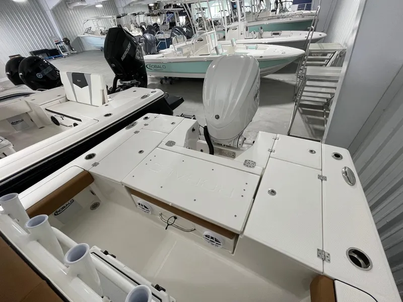 Slide: The Image of 2025 Robalo 246 Cayman boat interior with motor, in showroom setting. - 13