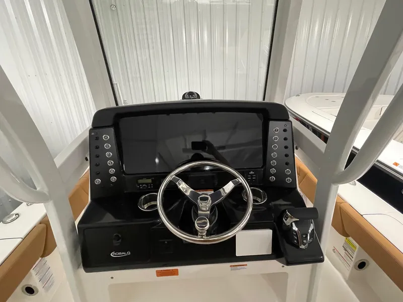 Slide: The Image of 2025 Robalo 246 Cayman boat dashboard with steering wheel and control panel. - 17