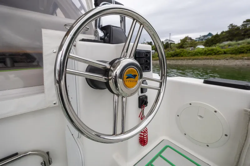 Slide: The Image of Steering wheel of a 2017 Cutwater C-302 Sport Coupe boat, docked near shoreline. - 11