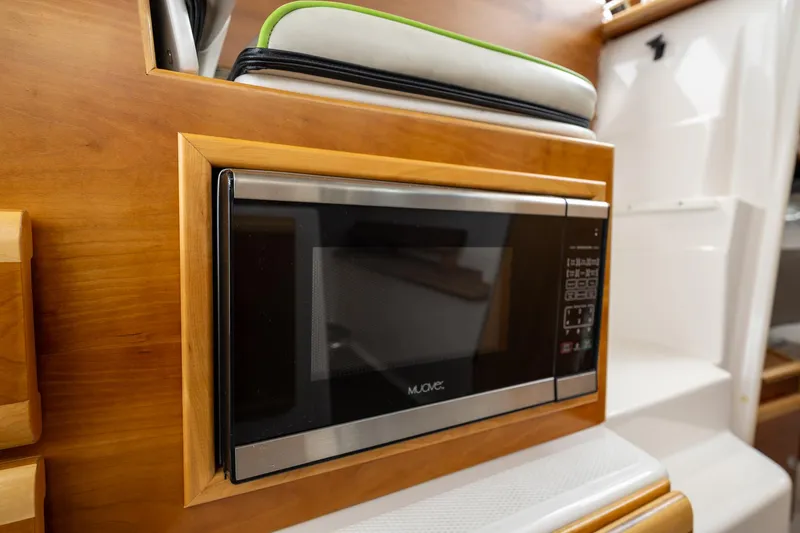 Slide: The Image of Microwave in 2017 Cutwater C-302 Sport Coupe's wooden interior kitchen area. - 19