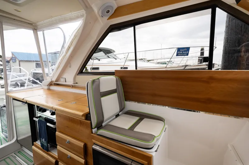 Slide: The Image of 2017 Cutwater C-302 Sport Coupe interior with wood cabinetry and cushioned seating. - 20