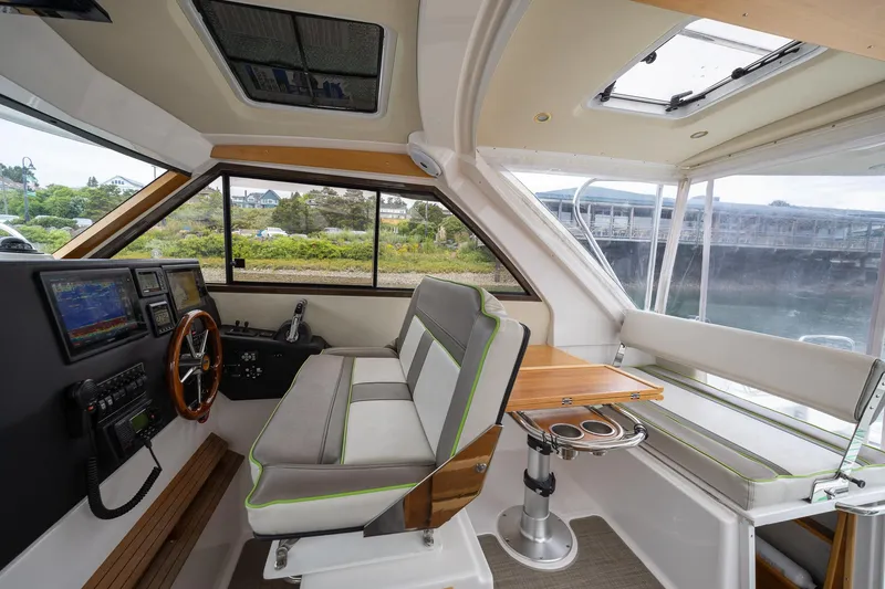 Slide: The Image of 2017 Cutwater C-302 Sport Coupe interior with helm, seating, and table, showcasing modern design. - 21