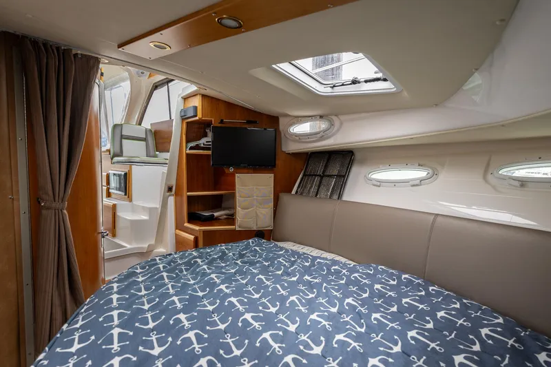 Slide: The Image of 2017 Cutwater C-302 Sport Coupe cabin interior with bed, TV, and portholes. - 27