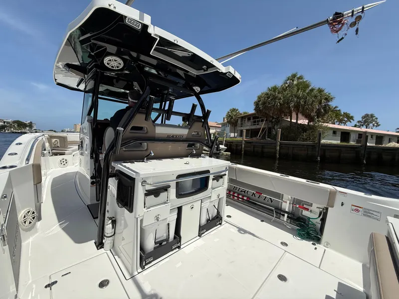 Slide: The Image of 2020 Blackfin 332 CC boat with spacious deck and modern amenities, docked by waterfront homes. - 19