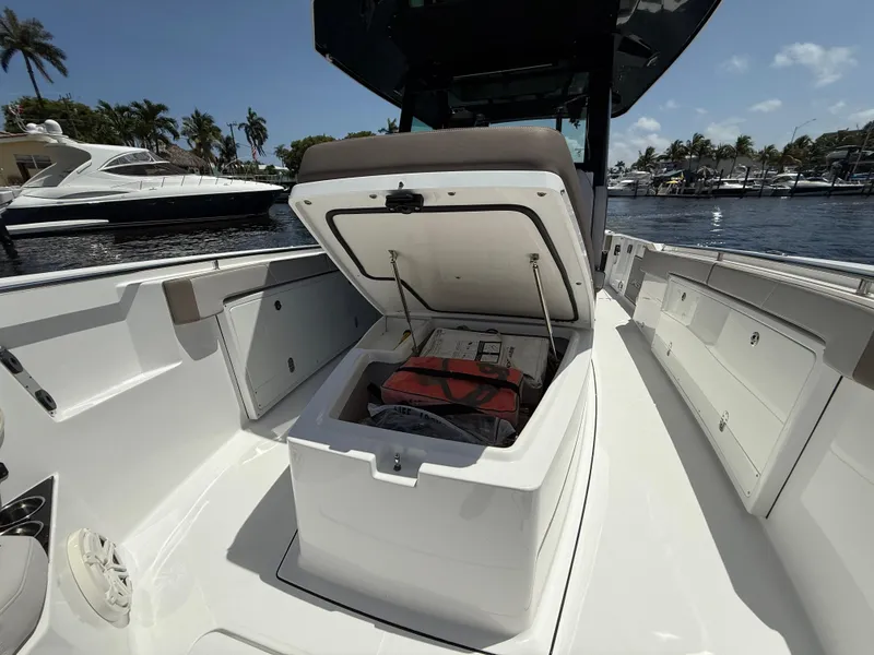Slide: The Image of 2020 Blackfin 332 CC boat with open storage compartment, docked near other boats. - 21