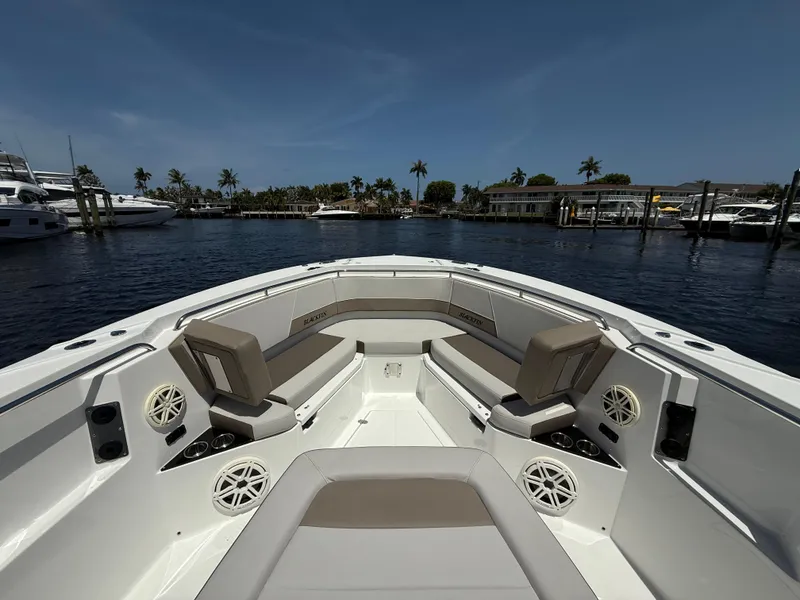 Slide: The Image of 2020 Blackfin 332 CC boat interior with seating, speakers, and cup holders, docked in a marina. - 23