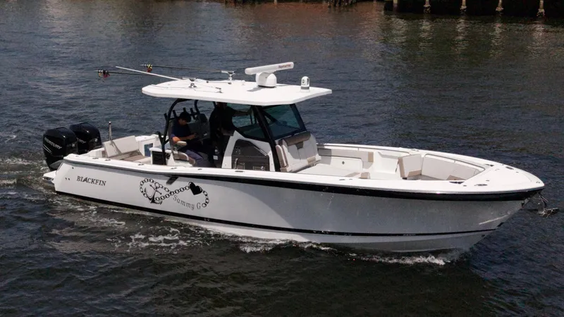 Slide: The Image of 2020 Blackfin 332 CC boat cruising on water, featuring sleek design and twin engines. - 3