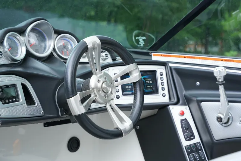 Slide: The Image of 2014 MasterCraft X-25 boat dashboard with steering wheel and control panel. - 14