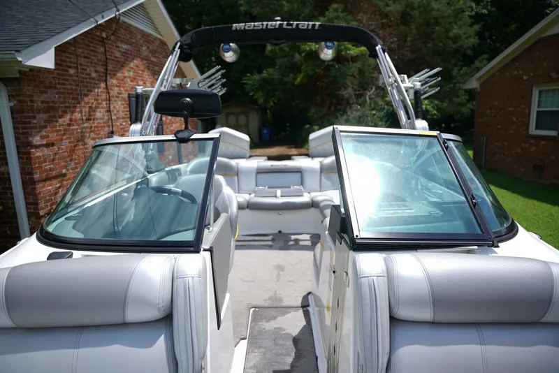 Slide: The Image of 2014 MasterCraft X-25 boat interior with open windshield, parked near brick house. - 18