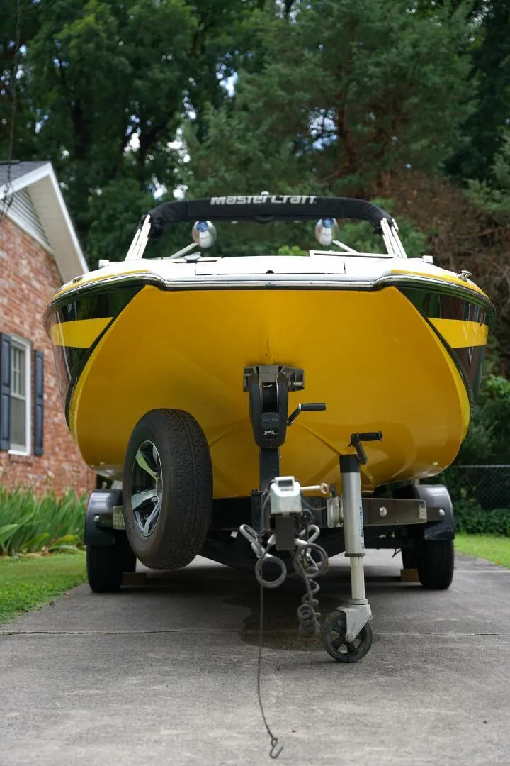 Slide: The Image of 2014 MasterCraft X-25 boat on trailer, rear view, parked on driveway with green lawn. - 9