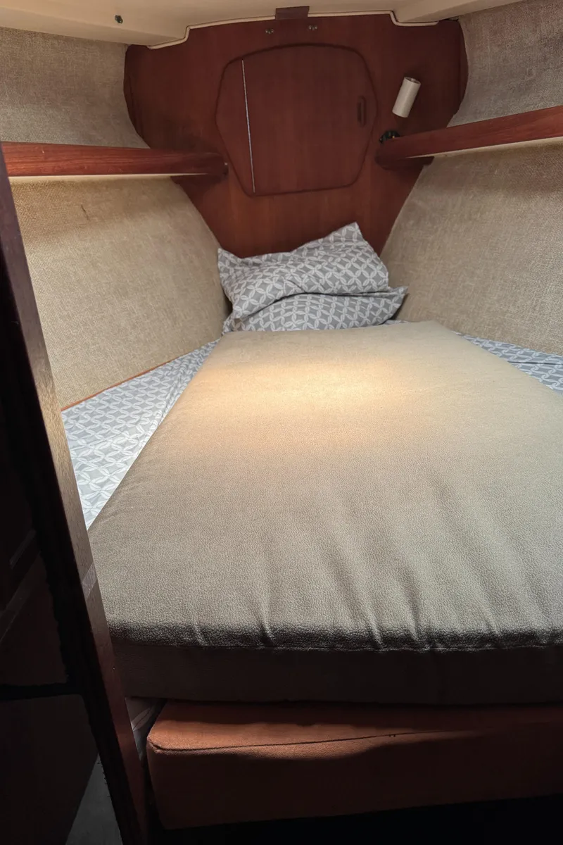 Slide: The Image of 1981 Morgan 416 Out Island cabin interior with cozy bedding and wooden accents. - 13