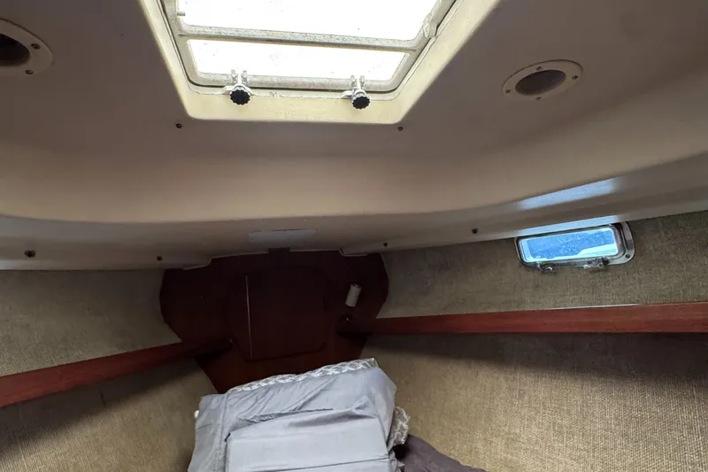 Slide: The Image of Interior cabin of a 1981 Morgan 416 Out Island sailboat, featuring a skylight and cozy bedding. - 14