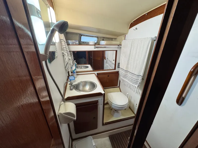 Slide: The Image of 1981 Morgan 416 Out Island yacht bathroom with sink, toilet, and showerhead. - 16