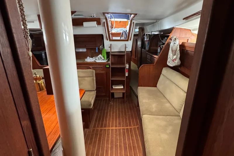 Slide: The Image of Interior of 1981 Morgan 416 Out Island sailboat, featuring cozy seating and wooden finishes. - 19