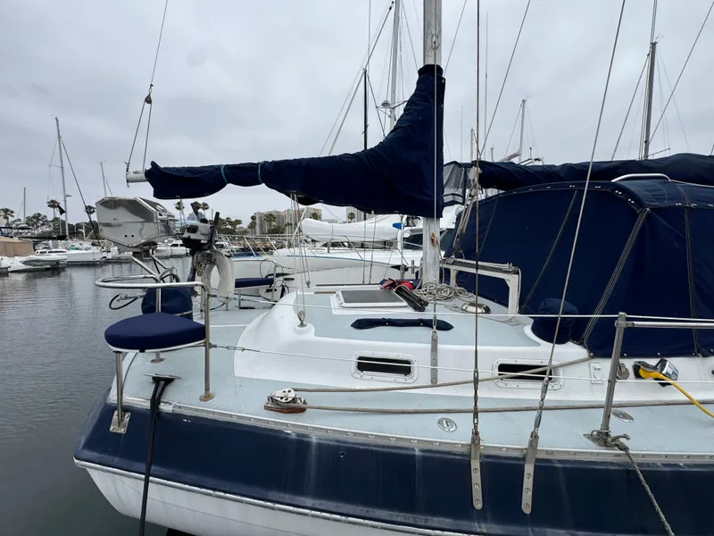 Slide: The Image of 1981 Morgan 416 Out Island sailboat docked in a marina, featuring blue covers and rigging. - 2