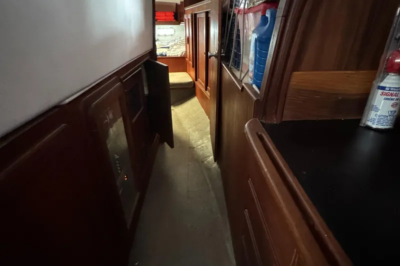 Slide: The Image of Narrow hallway inside 1981 Morgan 416 Out Island sailboat, featuring wooden cabinetry and storage. - 23