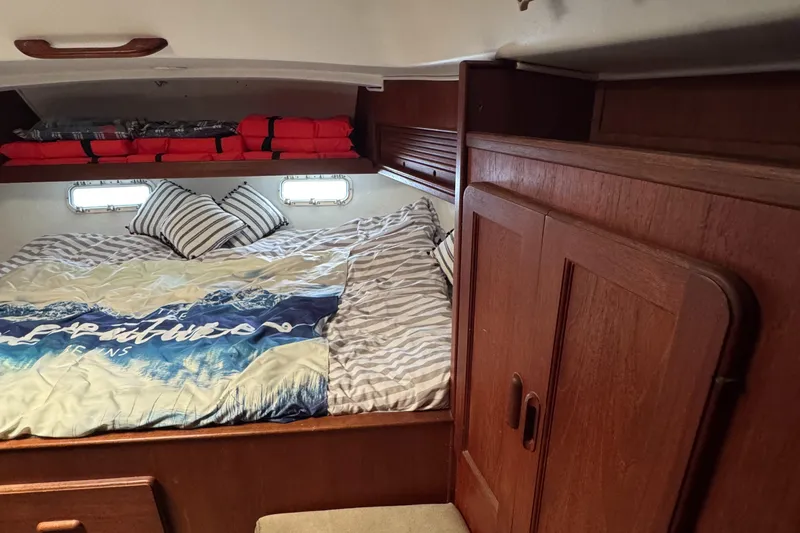 Slide: The Image of Cozy cabin interior of 1981 Morgan 416 Out Island sailboat with bed and wooden storage. - 25